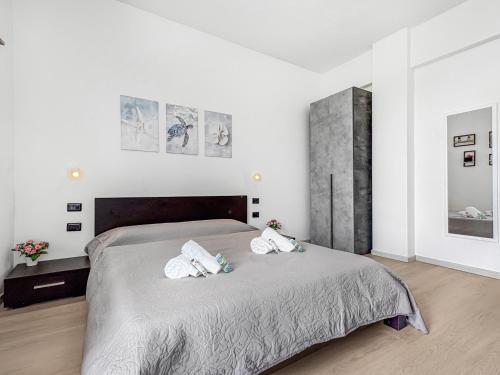 a bedroom with a large bed with towels on it at Victoria Seafront - Sea View Private Parking AC & WiFi in Savona