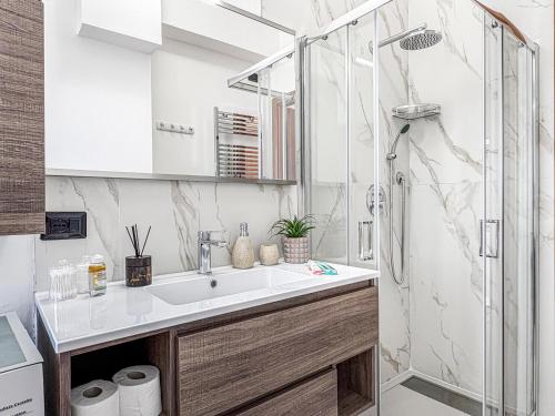 a bathroom with a sink and a shower at Victoria Seafront - Sea View Private Parking AC & WiFi in Savona