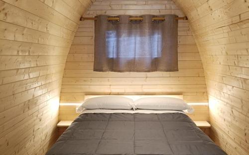 a bed in a wooden room with a window at Camping Cadí Vacances & Spa in Gósol