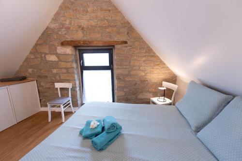 a bedroom with a bed with a blue towel on it at TY BERNIC maison en Pierre, lumineuse, 2 à 4 pers à Riec Sur Belon in Riec-sur-Bélon