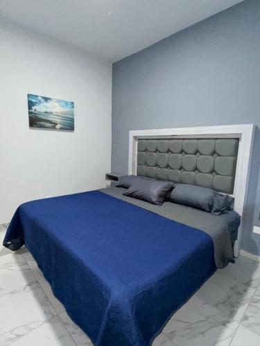 a bedroom with a large bed with a blue blanket at los agaves lto in Loreto