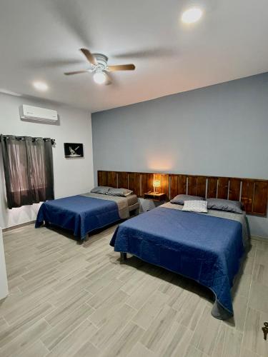 a bedroom with two beds and a ceiling fan at los agaves lto in Loreto