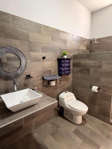 a bathroom with a white toilet and a sink at los agaves lto in Loreto