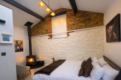 a bedroom with a bed and a stone wall at Copper Cove at Lough Sillan House - Adults only in Shercock