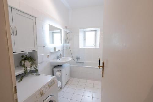a white bathroom with a sink and a toilet at Stadtvilla Alpenliebe in Bad Reichenhall