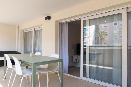 a dining room with a green table and white chairs at Nice Time - Chic Apartment with sunny terrace, Nice Port in Nice