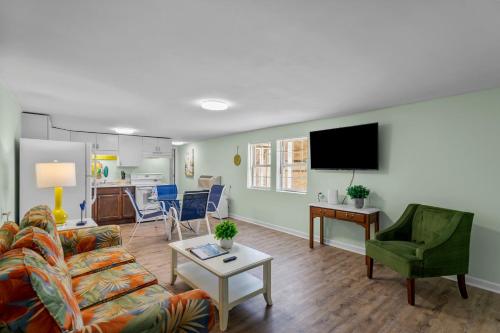 a living room with a couch and a tv at Sand Dollar Suites 2 in Carolina Beach