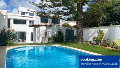 a swimming pool in front of a house at Vila Golfinho, with heated pool, rooftop lounge and ocean views in Luz