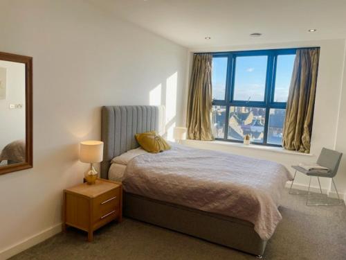 a bedroom with a bed and a large window at Top-end penthouse with sea views and free parking in Ramsgate
