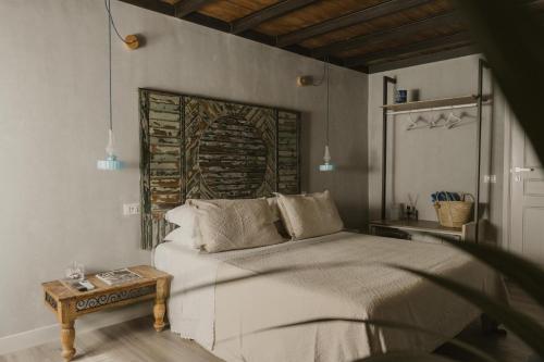 a bedroom with a large bed and a table at Al Cortile Del Seminario in Cefalù