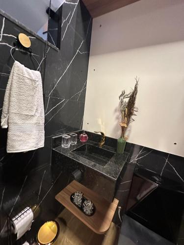 a bathroom with a black counter and a table at Flat jk 04 térreo in Juazeiro do Norte