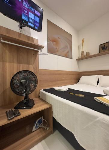 a bedroom with a bed and a fan and a television at Flat jk 04 térreo in Juazeiro do Norte
