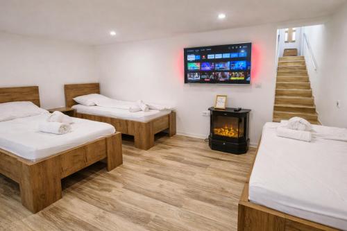 a room with two beds and a fireplace and a staircase at DINLUX Apartment in Maribor