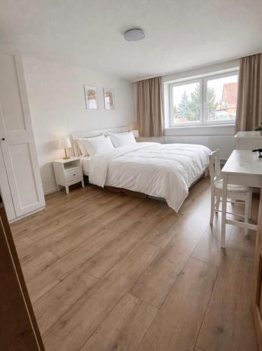 a bedroom with a large bed and a desk and a table at Apartmány Bozen Lednice in Lednice