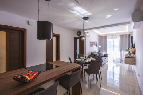 a kitchen and living room with a table and chairs at Luxury Parkside Living Near The 3 Cities in Malta in Tal-Ħamra