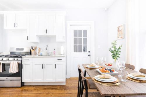 a kitchen with a wooden table and white cabinets at The Santiago Yale New Haven with Parking and Modern in New Haven
