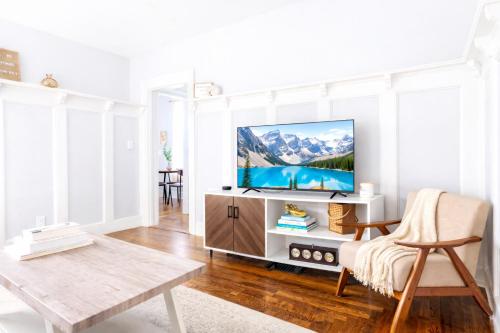 a living room with a flat screen tv on a cabinet at The Santiago Yale New Haven with Parking and Modern in New Haven