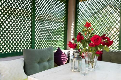 a table with a vase of red roses on it at Villa Igman in Hrasnica