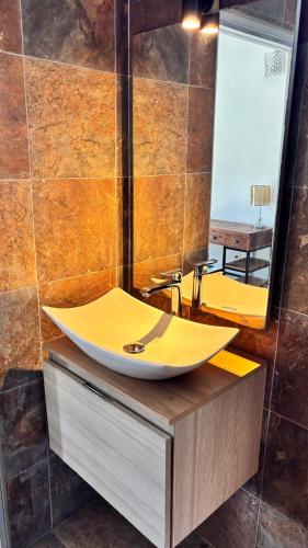 a bathroom with a sink on a wooden counter at Tropical Suite Direct Pool Access & Garden View in Baie-Mahault