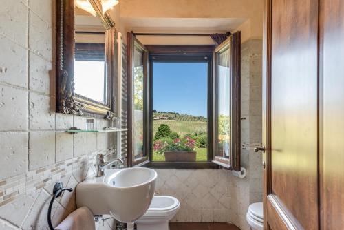 a bathroom with a sink and a toilet and a window at Villa Del Sole in San Gimignano