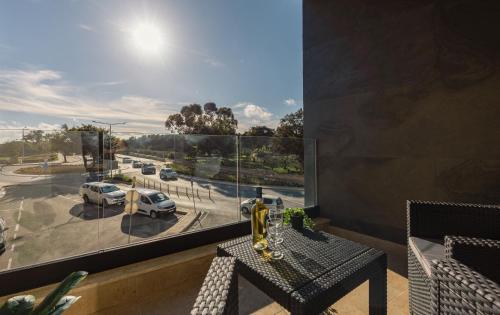 a balcony with a table and a view of a parking lot at Luxury Parkside Living Near The 3 Cities in Malta in Tal-Ħamra