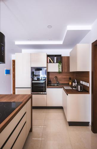 a kitchen with white cabinets and a counter top at Luxury Parkside Living Near The 3 Cities in Malta in Tal-Ħamra