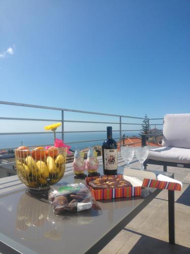 a table with food and wine on a balcony at Pearl Of The Sea in Ponta do Sol