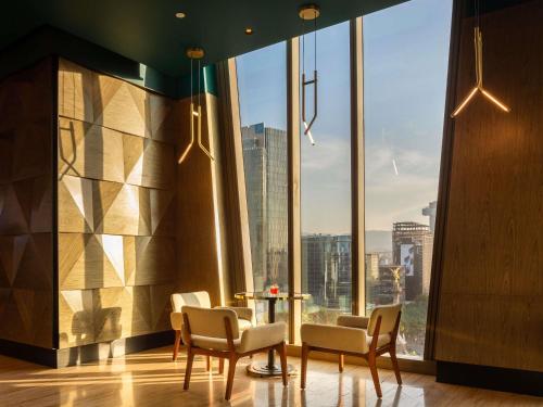 a room with chairs and a table in front of a large window at Sofitel Mexico City Reforma in Mexico City