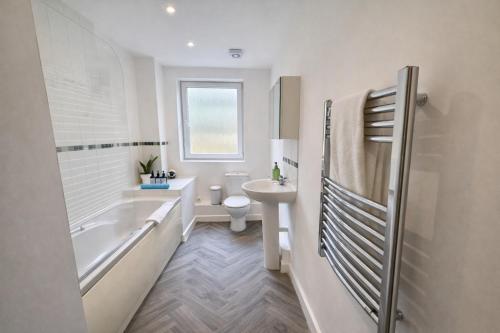 a bathroom with a tub and a toilet and a sink at Blueberry Tree Apartment with Free Parking & Near Station in Cambridge