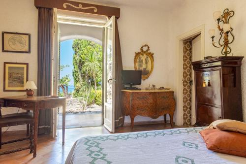 a bedroom with a bed and a desk with a television at Complesso Villa Le Palme in Forio d'Ischia