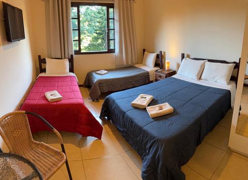 a hotel room with two beds with towels on them at Itaipava Cama e Café in Itaipava