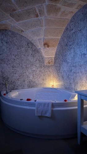 a white bath tub in a room with a stone wall at Samy Suite in Fasano