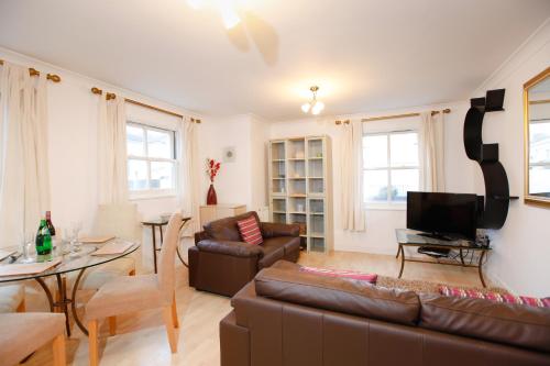 a living room with a couch and a tv at Leamington Spa Apartments in Leamington Spa