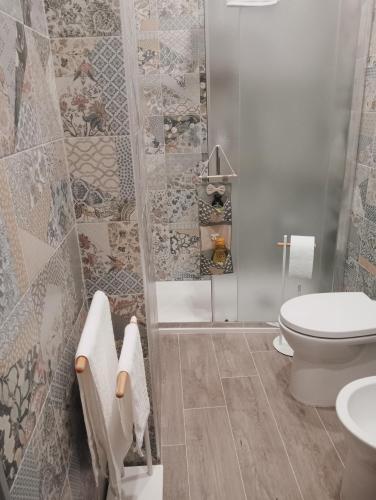 a bathroom with a toilet and a glass shower at La casa di Clizia in San Marco Evangelista