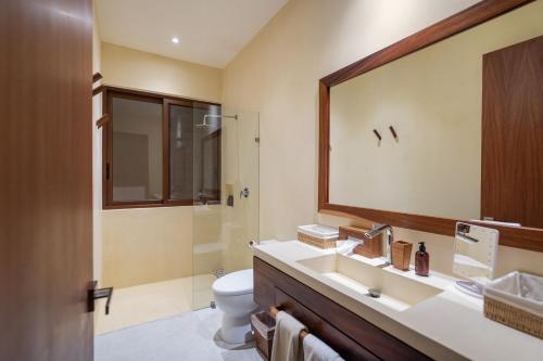 a bathroom with a sink and a toilet and a mirror at Casita VR09 in Zihuatanejo