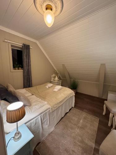 a small room with a bed and a lamp at Trollveggen in Åndalsnes