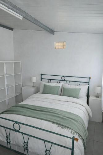 a bedroom with a bed with green and white pillows at Casa 3 quartos - Outeiro do Sul in Adopisco
