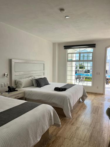a bedroom with two beds and a large window at Vita Grand San Miguel de Allende in San Miguel de Allende