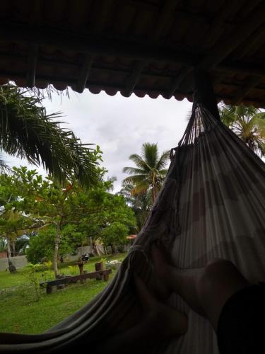 a person laying in a hammock in a park at Acampamento Dos Frangos in Itabuna