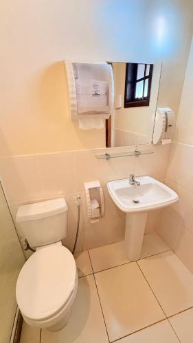a bathroom with a toilet and a sink at Itaipava Cama e Café in Itaipava