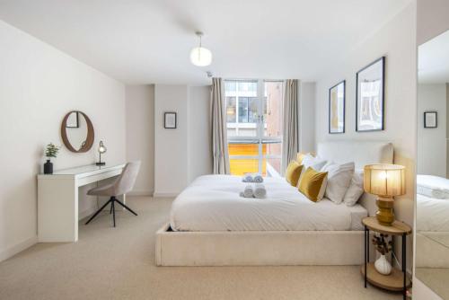 a white bedroom with a bed and a desk at 5 Mins Walk to Moorgate, Tranquil City Retreat in London