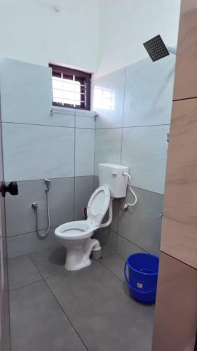 a bathroom with a toilet and a window at Star Varkala Homestay in Varkala