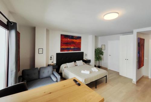a living room with a bed and a couch at Suite imperial Muralla de Lugo 2.2 in Lugo