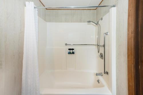 a bathroom with a shower with a white shower curtain at Sol Duc Hot Springs Resort in Ovington