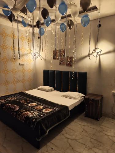 a bedroom with a bed with balloons hanging from the ceiling at The Moksha Residency in Prayagraj