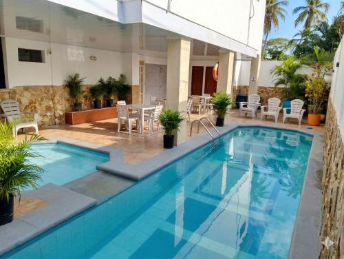 a pool in a hotel with chairs and a table at Olas del Mar Hotel by GHO Hoteles in Santa Marta