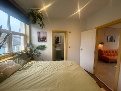 a bedroom with a bed and an orange chair at Sauna Haus in Brighton & Hove