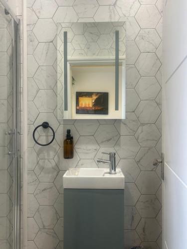 a white bathroom with a sink and a mirror at Sauna Haus in Brighton & Hove