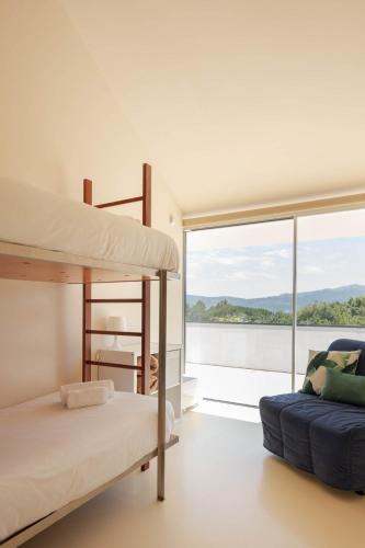 a bedroom with two bunk beds and a large window at Slope Design Villa - Architecture villa with private pool in Ponte de Lima