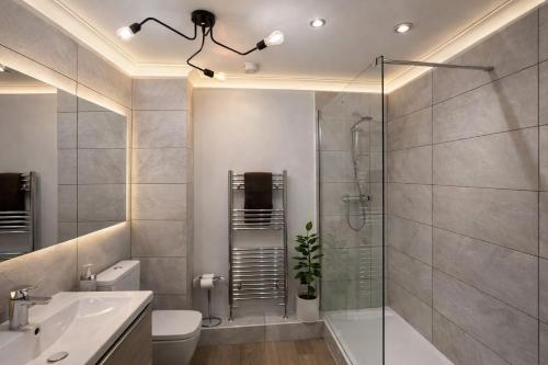 a bathroom with a shower and a toilet and a sink at Mango Tree Apartment - Near Leisure Park & Station in Cambridge